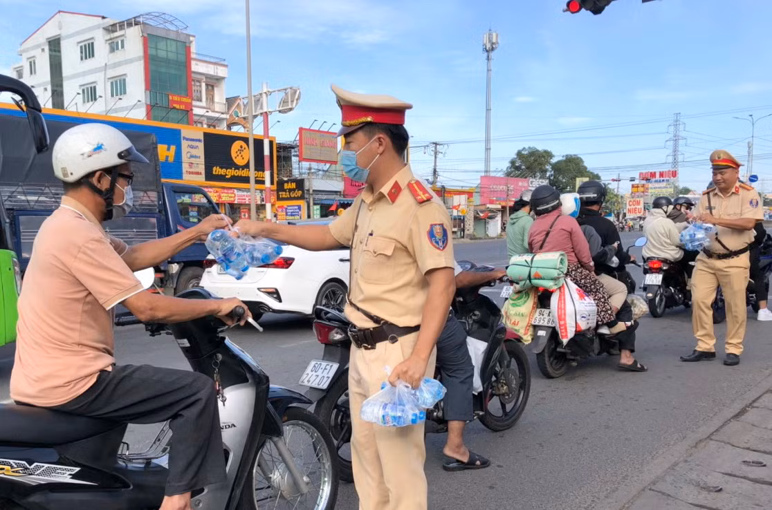 Chiến sĩ Cảnh sát giao thông Đồng Nai phát nước suối cho người dân trên quốc lộ 51. Chiến sĩ Cảnh sát giao thông Đồng Nai phát nước suối cho người dân trên quốc lộ 51.