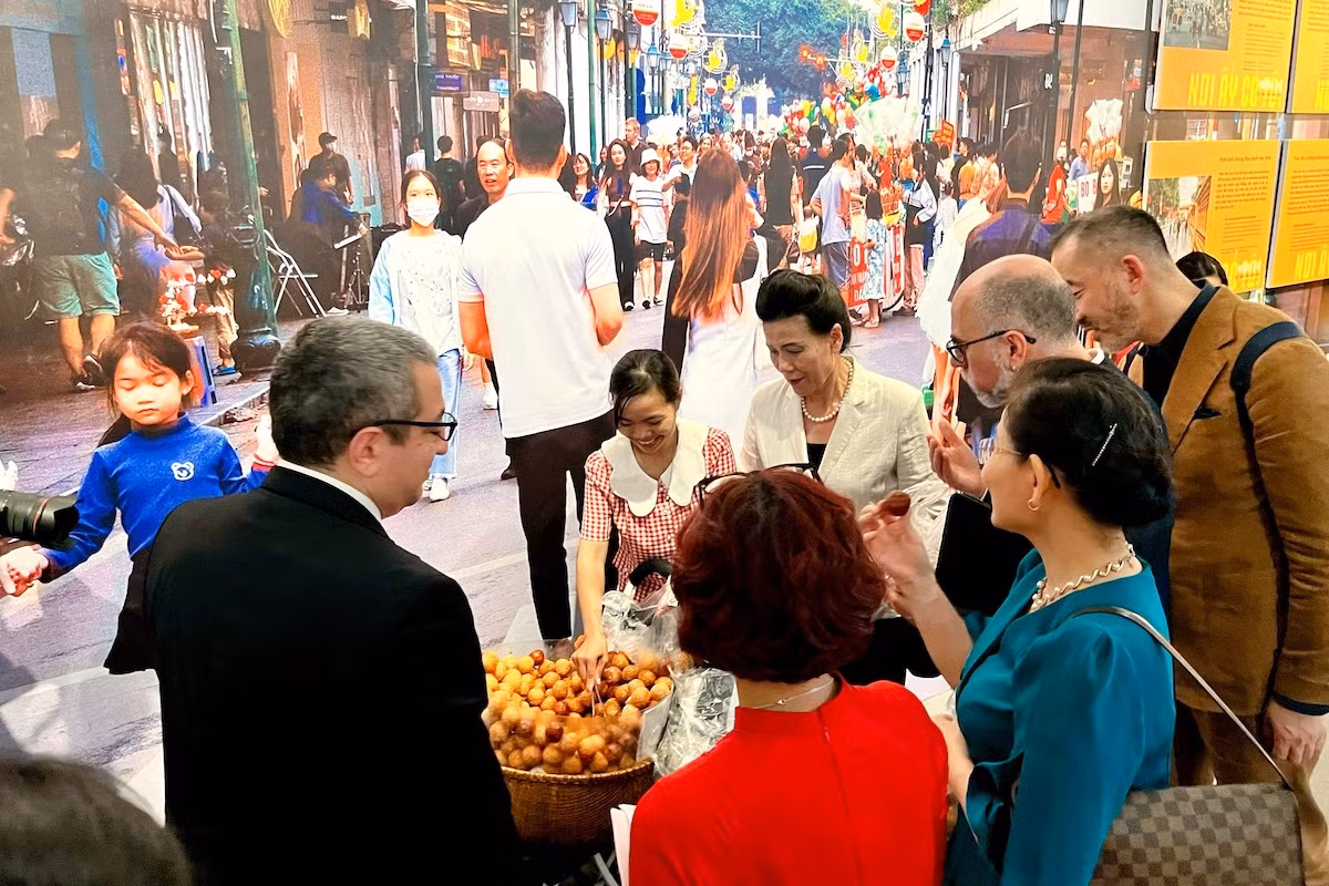 Khách tham quan triển lãm trải nghiệm một công việc khá phổ biến với các nữ lao động di cư: Bán rong bánh rán.