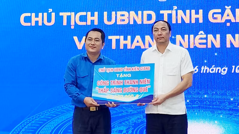 Chủ tịch Ủy ban nhân dân tỉnh Kiên Giang Lâm Minh Thành (bên phải) tặng 1 công trình thanh niên “Thắp sáng đường quê” trị giá 50 triệu đồng cho tuổi trẻ tỉnh nhà.