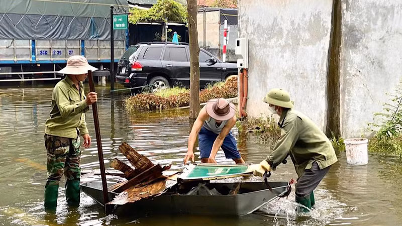 Lực lượng chức năng dọn dẹp rác thải nguy hiểm như tôn lá, cọc sắt, kính vỡ ở các khu vực ngập úng.