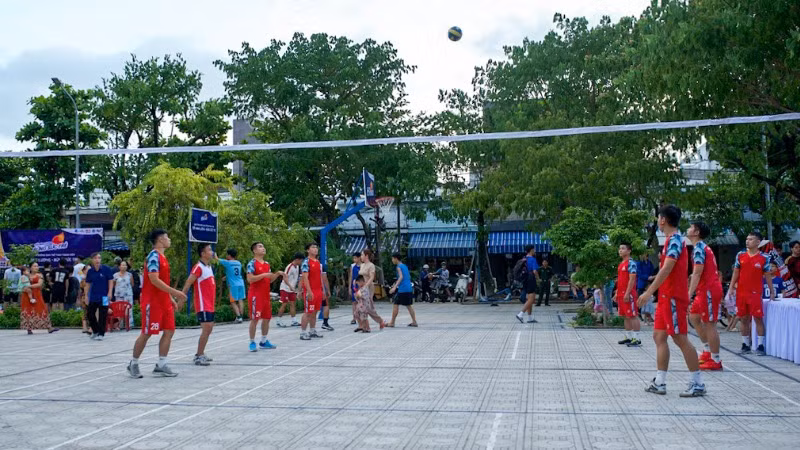 Thanh niên ra sân đánh bóng chuyền trong ngày khánh thành.