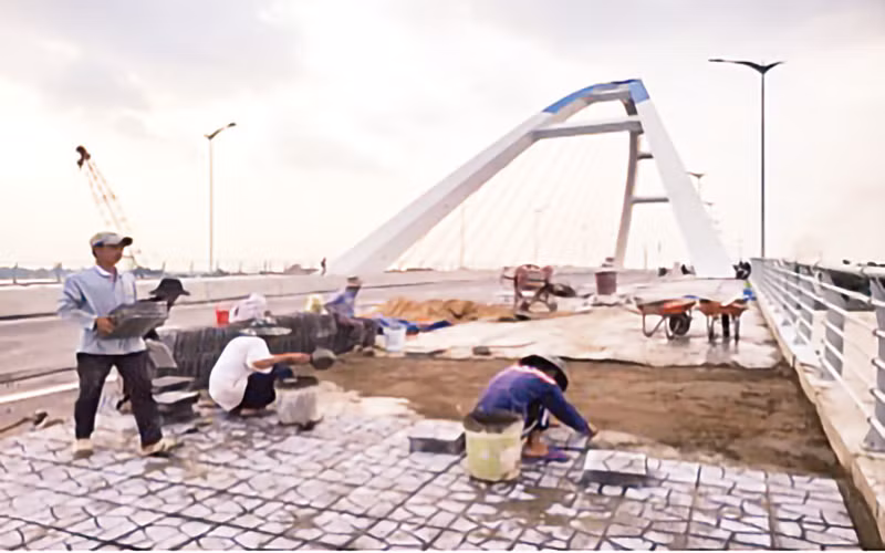 Công nhân lát gạch vỉa hè khu vực ngắm cảnh bên thành cầu Trần Hoàng Na.