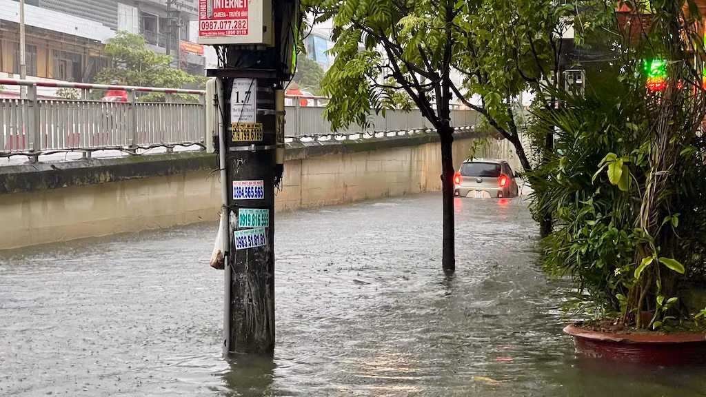 Một chiếc ô-tô bị chết máy do đi vào khu vực ngập sâu gần phố Máy Chai.