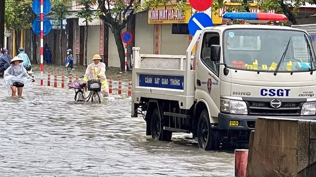 Một chiến sĩ dắt xe cho người dân tại điểm ngập chân cầu Đò Quan, thành phố Nam Định. Một chiến sĩ dắt xe cho người dân tại điểm ngập chân cầu Đò Quan, thành phố Nam Định.