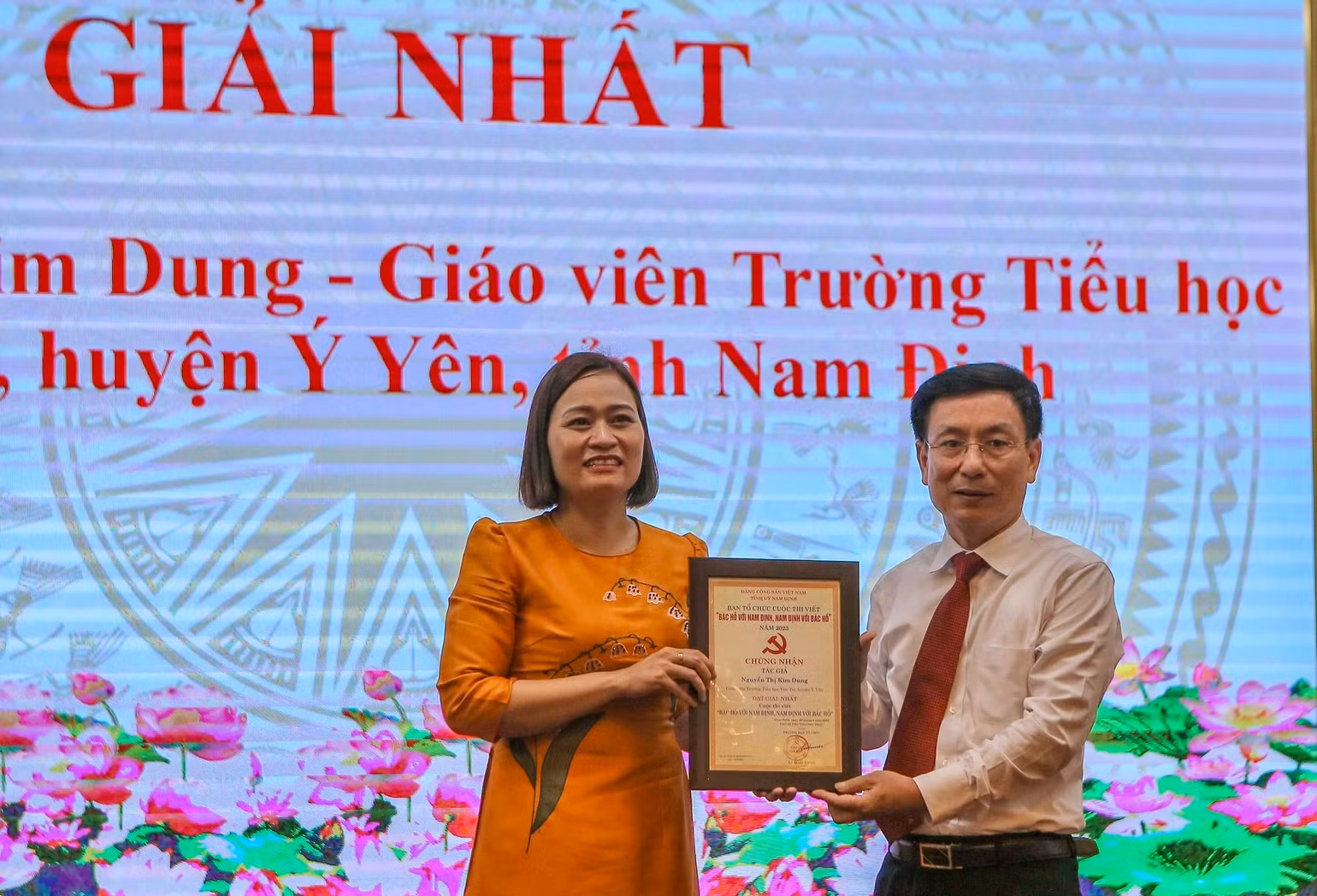 Đồng chí Phạm Đình Nghị, Chủ tịch Ủy ban nhân dân tỉnh Nam Định trao giải Nhất cho bà Nguyễn Thị Kim Dung, giáo viên Trường Tiểu học Yên Trị, huyện Ý Yên.