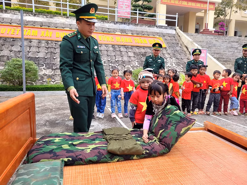 Hướng dẫn các cháu cách gấp chăn màn.