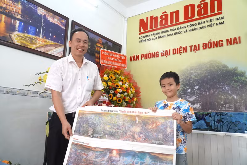 Bé Ngọc Châu đón nhận tranh từ đại diện Văn phòng đại diện Báo Nhân Dân tại Đồng Nai.