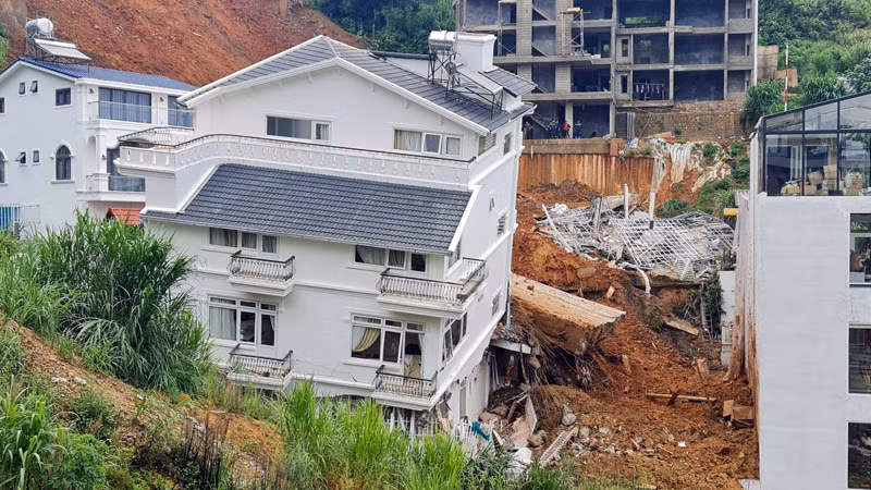 Ngôi nhà bị xô lệch, nghiêng bên sườn đồi sau vụ sạt lở.