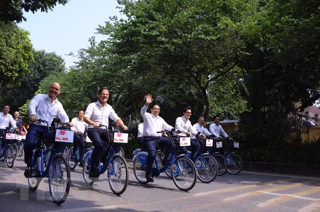 Thủ tướng Phạm Minh Chính cùng Thủ tướng Hà Lan Mark Rutte đạp xe trên đường phố Hà Nội. (Ảnh: Văn Điệp/TTXVN)
