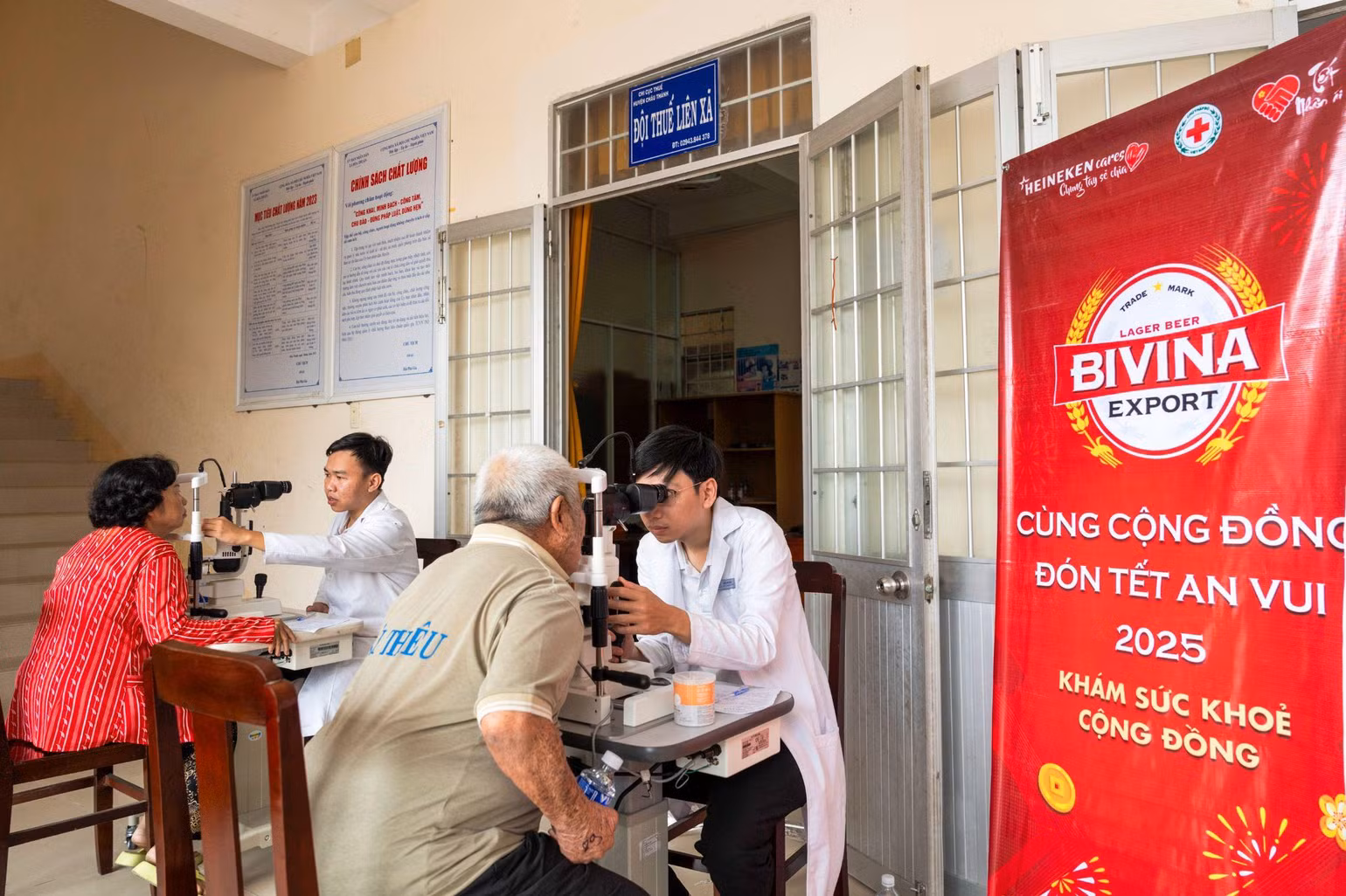 Người dân được chăm sóc sức khỏe và khám mắt bởi các chuyên viên y tế.