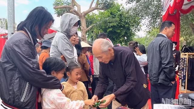 Nghệ nhân Hoàng Choóng giới thiệu sản phẩm gà đất gáy cho trẻ nhỏ.