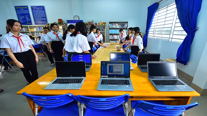 Các em học sinh vui mừng đón nhận máy tính và sách mới được tặng