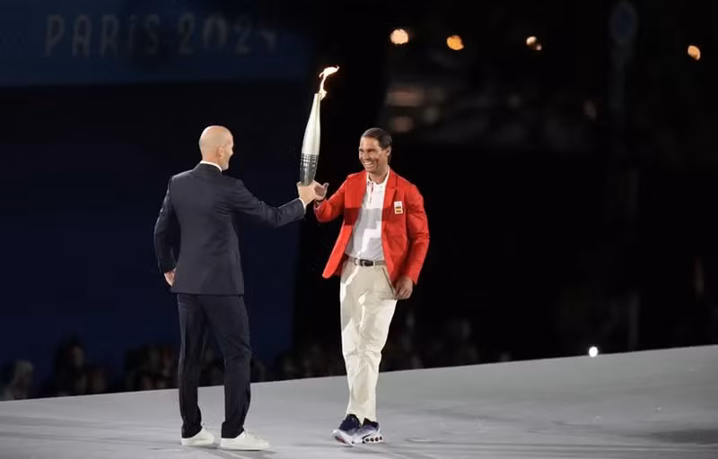 Cầu thủ Zinedine Zidane của Pháp trao lại ngọn đuốc Thế vận hội cho tay vợt huyền thoại người Tây Ban Nha Rafael Nadal. (Ảnh: 20minutes)