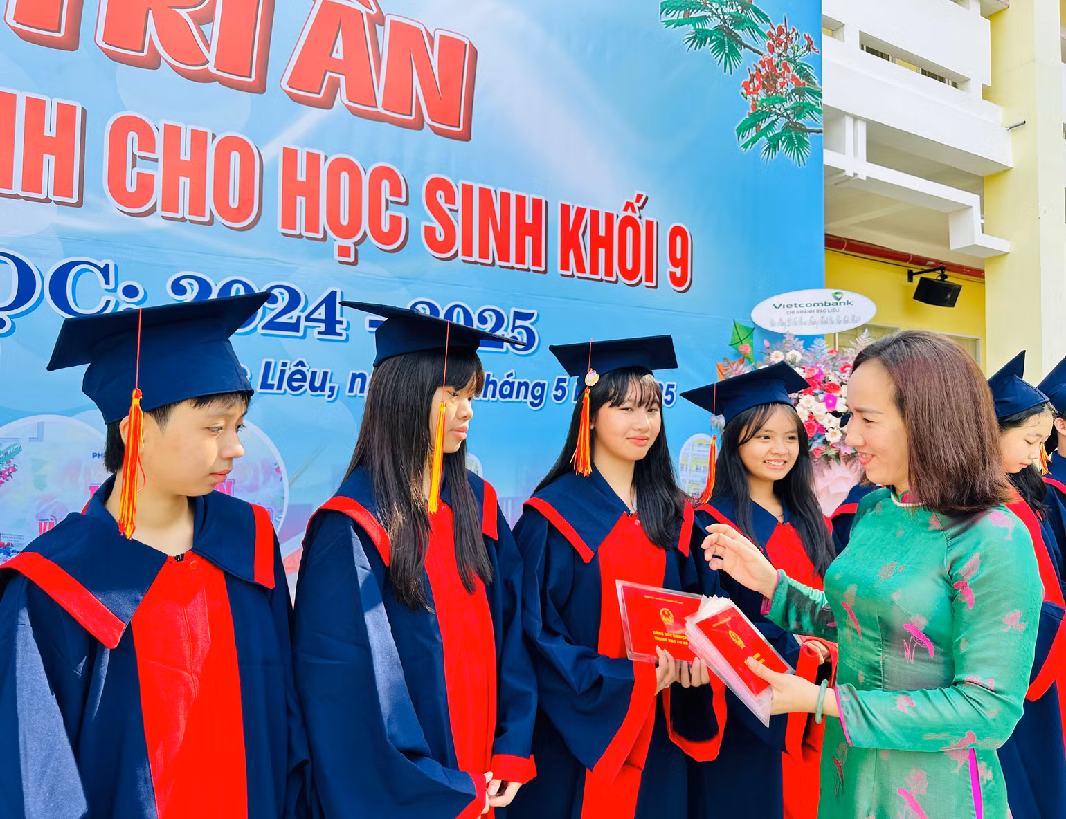 Cô Trần Kim Thi, Hiệu trưởng Trường trung học cơ sở Lê Thị Cẩm Lệ (thành phố Bạc Liêu), trao giấy tốt nghiệp trung học cơ sở cho các em học sinh của trường, năm học 2024-2025. (Ảnh: TRỌNG DUY)