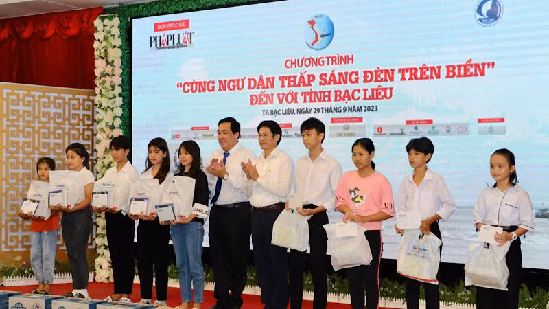 Đại diện lãnh đạo báo Pháp Luật Thành phố Hồ Chí Minh và lãnh đạo tỉnh Bạc Liêu trao quà cho học sinh nghèo vùng ven biển Bạc Liêu.
