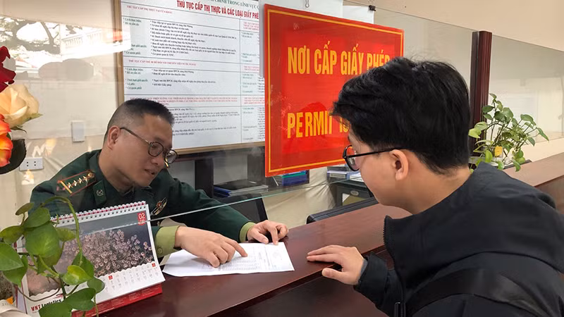 Cán bộ chiến sĩ hướng dẫn nhân viên đại lý hoàn thiện hồ sơ thủ tục.
