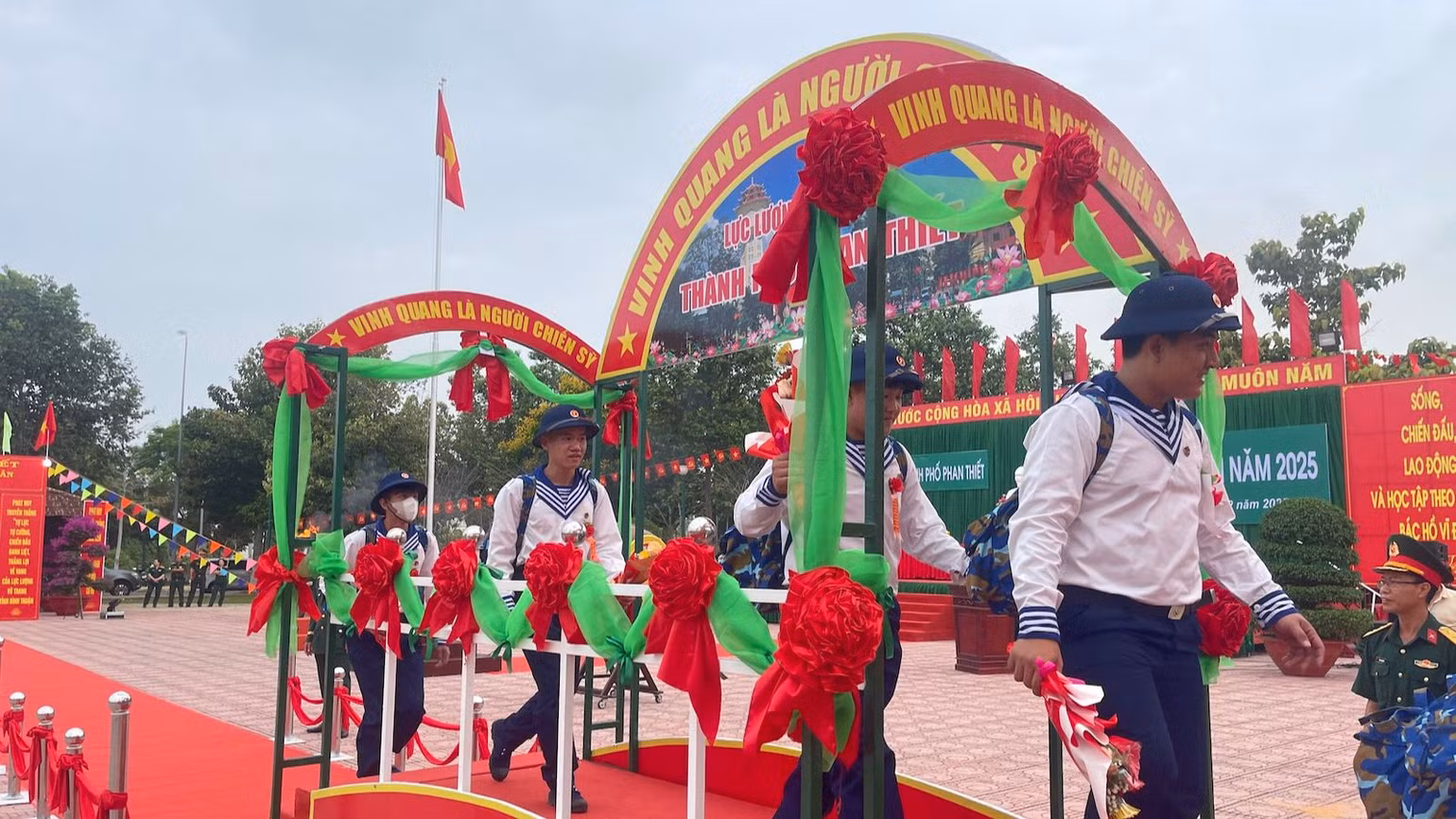 Các tân binh cầm những bông hoa tươi thắm lên đường nhập ngũ.
