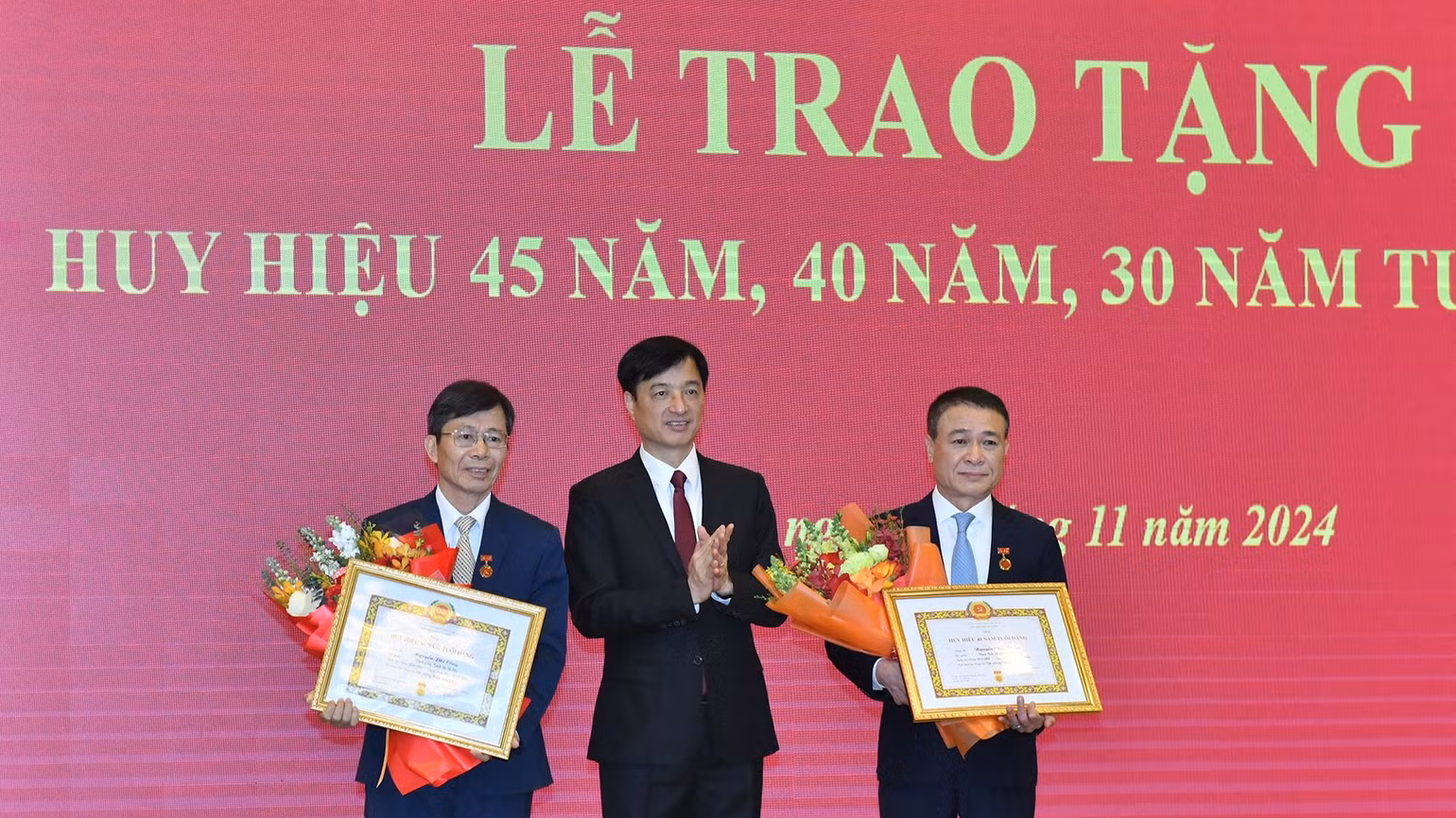 Đồng chí Nguyễn Duy Ngọc, Bí thư Trung ương Đảng, Chánh Văn phòng Trung ương Đảng trao Huy hiệu 40 năm tuổi đảng và tặng hoa chúc mừng các đồng chí cán bộ Văn phòng Trung ương Đảng. (Ảnh: ĐĂNG KHOA)