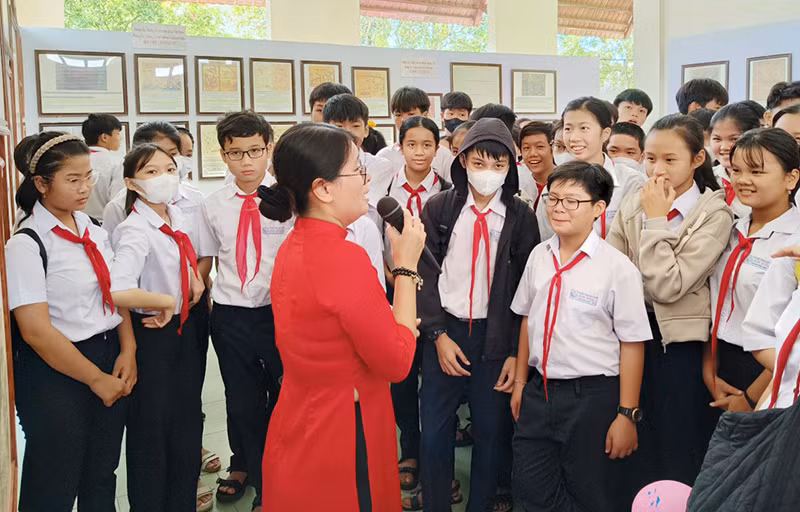 Các em học sinh của huyện Núi Thành (Quảng Nam) nghe giới thiệu những tư liệu, bản đồ về hai quần đảo Hoàng Sa và Trường Sa của Việt Nam.