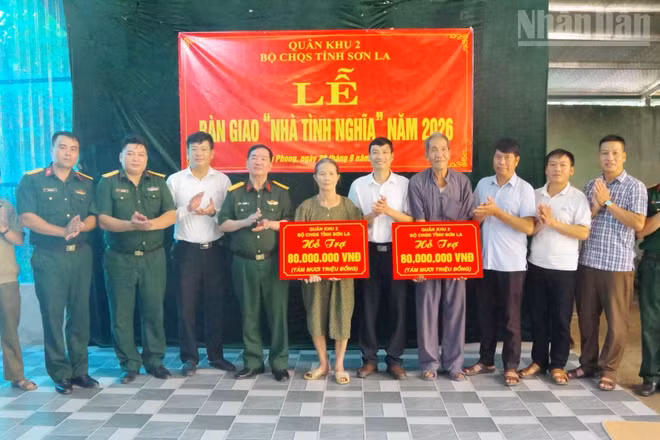 Lãnh đạo Bộ Chỉ huy Quân sự tỉnh Sơn La và xã Tân Phong trao tiền hỗ trợ làm nhà cho các gia đình chính sách. (Ảnh: THỌ SƠN)