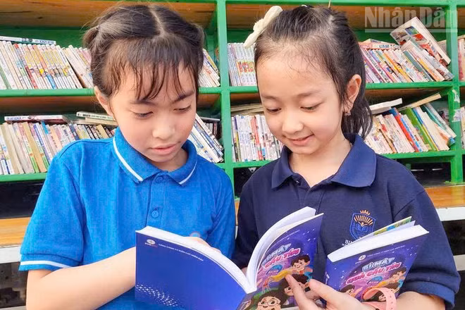 Các em học sinh rất hào hứng khi được tặng sách thiếu nhi “Bí mật quả cầu tím”.