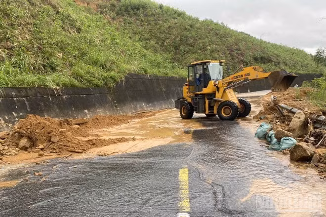 Công nhân túc trực dọn đất đá theo mưa lũ chảy xuống mặt đường để bảo đảm an toàn giao thông.