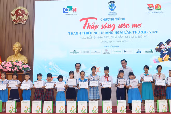 Lãnh đạo tỉnh Quảng Ngãi và đại diện Quỹ học bổng Thắp sáng ước mơ trao học bổng cho học sinh nghèo, vượt khó học giỏi. (Ảnh: HIỂN CỪ)
