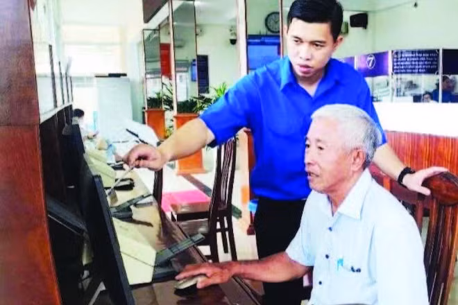 Chuyên viên Tổ công nghệ số cộng đồng phường Long An hướng dẫn người dân nộp hồ sơ trực tuyến tại Trung tâm hành chính công phường.