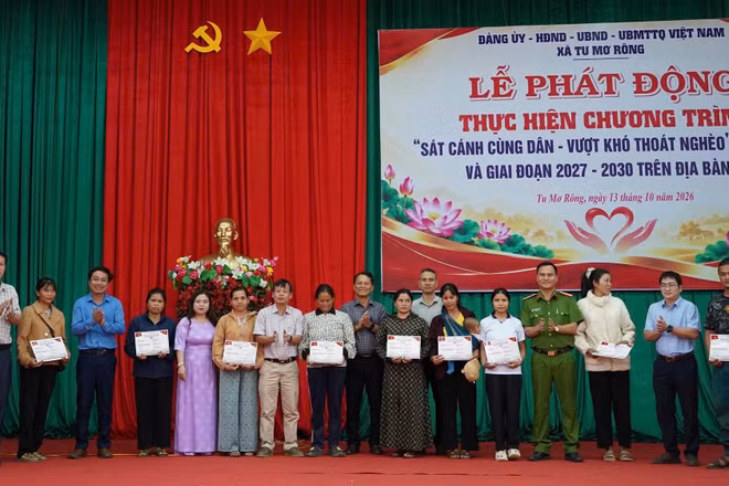 Các Ủy viên Ban Thường vụ Đảng ủy xã Tu Mơ Rông trao phiếu nhận đồng hành cho các hộ nghèo có hoàn cảnh khó khăn. (Ảnh: BT)