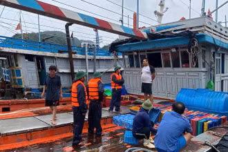 Cán bộ, chiến sĩ Hải đoàn Biên phòng 38 vận động người dân gia cố, chằng buộc phương tiện tránh, trú bão. (Ảnh: HÀ VINH)