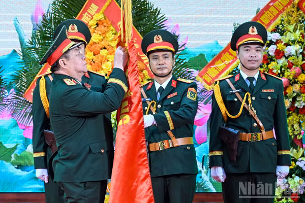 Thừa ủy quyền của Chủ tịch nước, Đại tướng Nguyễn Trọng Nghĩa trao danh hiệu Anh hùng Lực lượng vũ trang nhân dân tặng Học viện Kỹ thuật Quân sự. (Ảnh: THẾ ĐẠI)