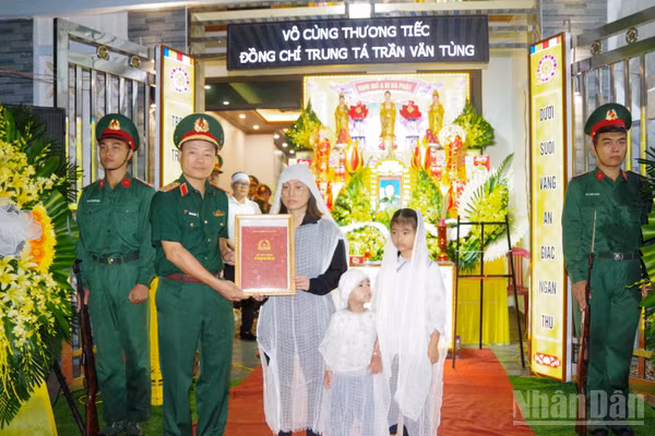 Trung tướng Lương Văn Kiểm, Phó Bí thư Đảng ủy, Tư lệnh Quân khu trao quyết định truy thăng quân hàm sĩ quan trước thời hạn của Bộ trưởng Quốc phòng cho thân nhân của Trung tá Trần Văn Tùng.