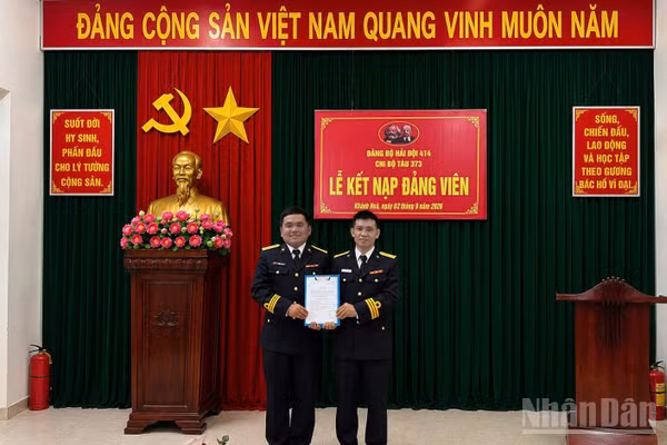 Đồng chí Thiếu tá Võ Tá Kiên, Bí thư Chi bộ Tàu 373, Hải đội 414 trao quyết định cho đồng chí Trần Văn Lượng.