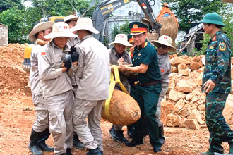 Các lực lượng phối hợp di dời, xử lý quả bom còn sót lại sau chiến tranh. (Ảnh: LA)