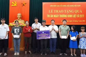 Các đại biểu trao quà cho gia đình chính sách và học bổng cho con em gia đình chính sách tại Quảng Bình.