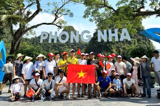 Du khách chụp ảnh lưu niệm trước khi xuống thuyền tham quan động Phong Nha và động Tiên Sơn.