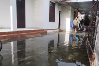 Sân nhà người dân ở Linh Cận Sơn, xã Quảng Sơn, thị xã Ba Đồn bị ngập trong mùa hè do nước công trình thủy lợi tràn vào.