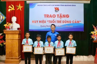 Phó Bí thư Tỉnh Đoàn, Chủ tịch Hội đồng Đội tỉnh Quảng Bình Đinh Trung Hiếu trao tặng Huy hiệu tuổi trẻ dũng cảm cho 5 đội viên.