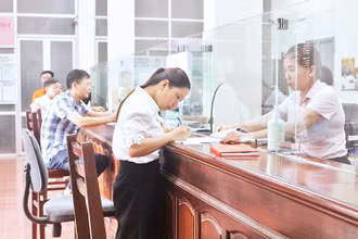 Nhân viên Ngân hàng Chính sách xã hội thị xã Duy Tiên giải ngân cho khách hàng vay để mua nhà ở xã hội.