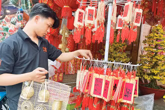 Khách hàng lựa chọn đồ trang trí Tết thuần Việt bày bán trên đường Hải Thượng Lãn Ông, Quận 5.