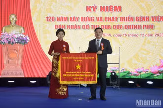 Đồng chí Nguyễn Khắc Thận, Phó Bí thư Tỉnh ủy, Chủ tịch Ủy ban nhân dân tỉnh Thái Bình trao Cờ thi đua của Chính phủ cho Bệnh viện đa khoa tỉnh.