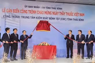 Các đại biểu thực hiện nghi thức gắn biển công trình chào mừng Ngày Thầy thuốc Việt Nam cho tòa nhà CDC Thái Bình.