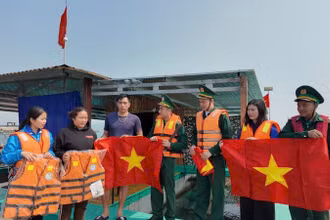 Đồn Biên phòng Cô Tô và Đoàn thanh niên thị trấn Cô Tô tặng cờ Tổ quốc và áo phao cho ngư dân.