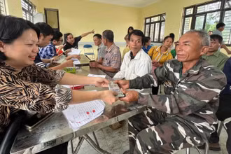 Cán bộ Công ty Cổ phần Cao-su Điện Biên chi trả tiền góp đất cho các hộ dân trên địa bàn huyện Mường Chà.