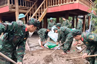 Cán bộ, chiến sĩ Tiểu đoàn 1, Trung đoàn 741 giúp người dân xã Mường Toong, huyện Mường Nhé sửa nhà.