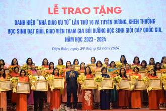 Đồng chí Lò Văn Tiến, Phó Chủ tịch Ủy ban nhân dân tỉnh Điện Biên trao danh hiệu "Nhà giáo Ưu tú" tặng các thầy giáo, cô giáo.