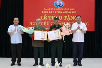 Đồng chí Trần Quốc Cường, Bí thư Tỉnh ủy Điện Biên và đồng chí Mùa A Sơn, Phó Bí thư Thường trực Tỉnh ủy Điện Biên tặng hoa, chúc mừng 2 chiến sĩ Điện Biên vinh dự được nhận Huy hiệu 70 năm tuổi Đảng.