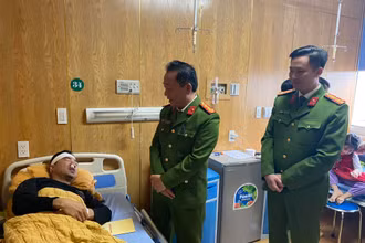 Đại tá Nguyễn Xuân Tuấn cùng lãnh đạo công an thành phố Yên Bái thăm, động viên Thượng úy Trần Trung Đức tại khoa Chấn thương. (Ảnh: THANH SƠN)
