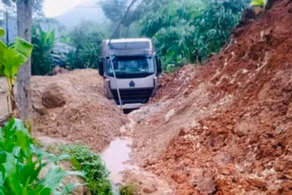 Xe đầu kéo bị đất đá vùi lấp tại đường tỉnh 164. (Ảnh: THANH SƠN)