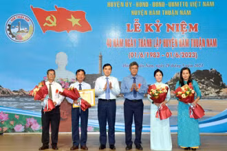 Đại diện lãnh đạo tỉnh Bình Thuận trao Bằng khen của Chủ tịch Ủy ban nhân dân tỉnh và tặng hoa chúc mừng cán bộ, nhân dân huyện Hàm Thuận Nam.